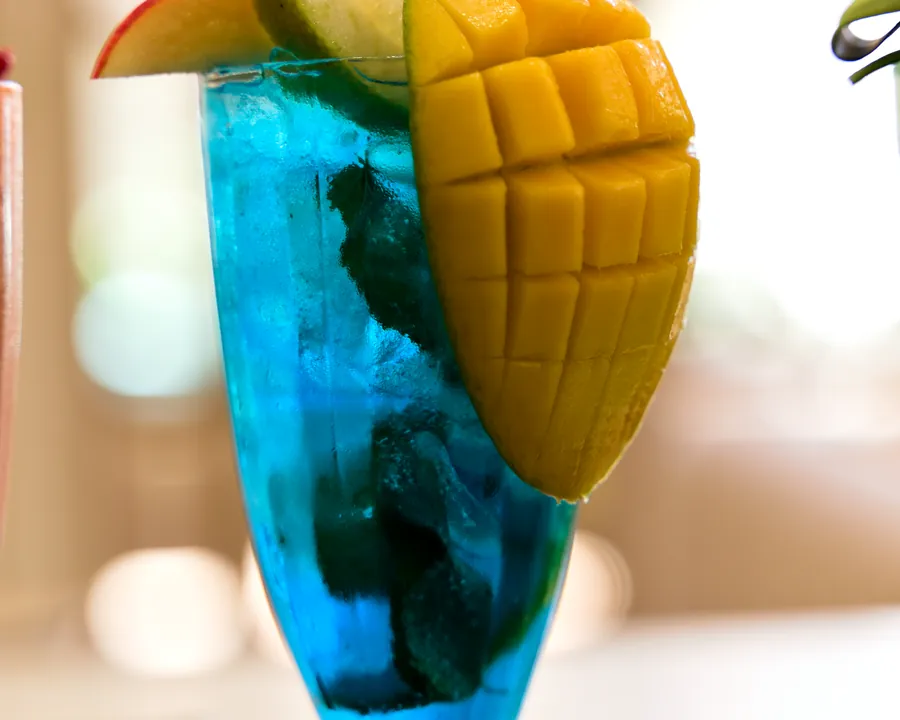 Boisson bleue garnie de mangue photographiée en portrait